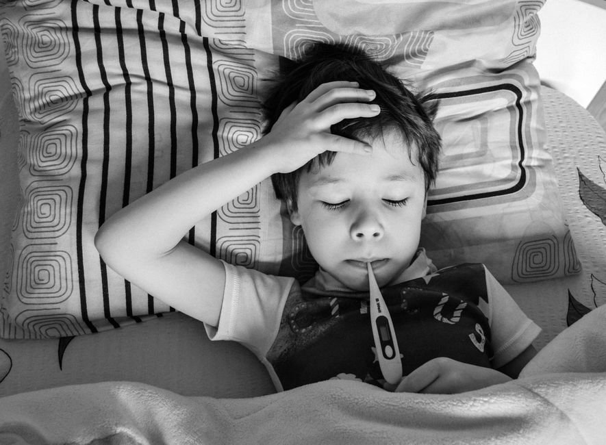 child lying in bed unwell