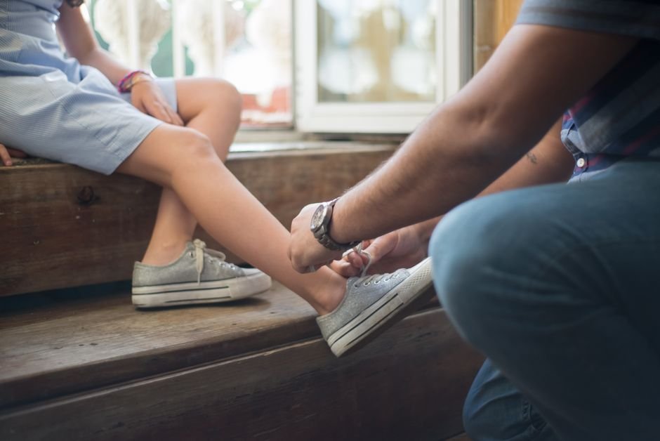 parent tying child shoelaces